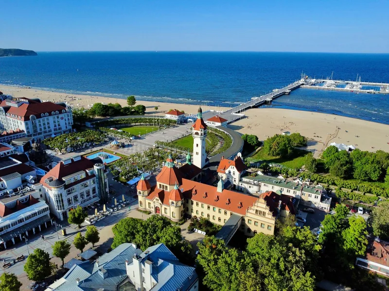 Widok z drona na zabytkowe budynki, molo i plażę w Sopocie.